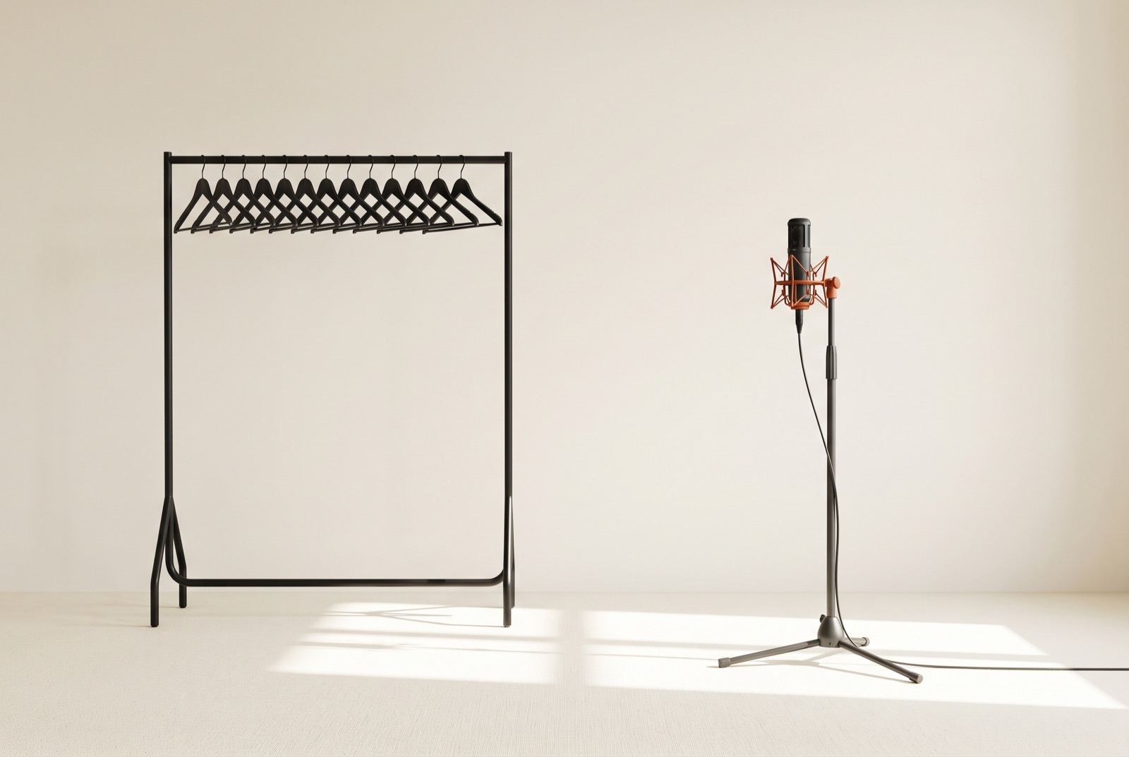 An empty costume rack with bare hangers beside a lone studio microphone on a stand